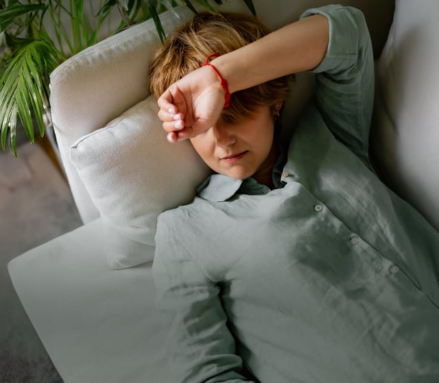 Brystkreftsyk kvinne ligger på sofaen med fatigue