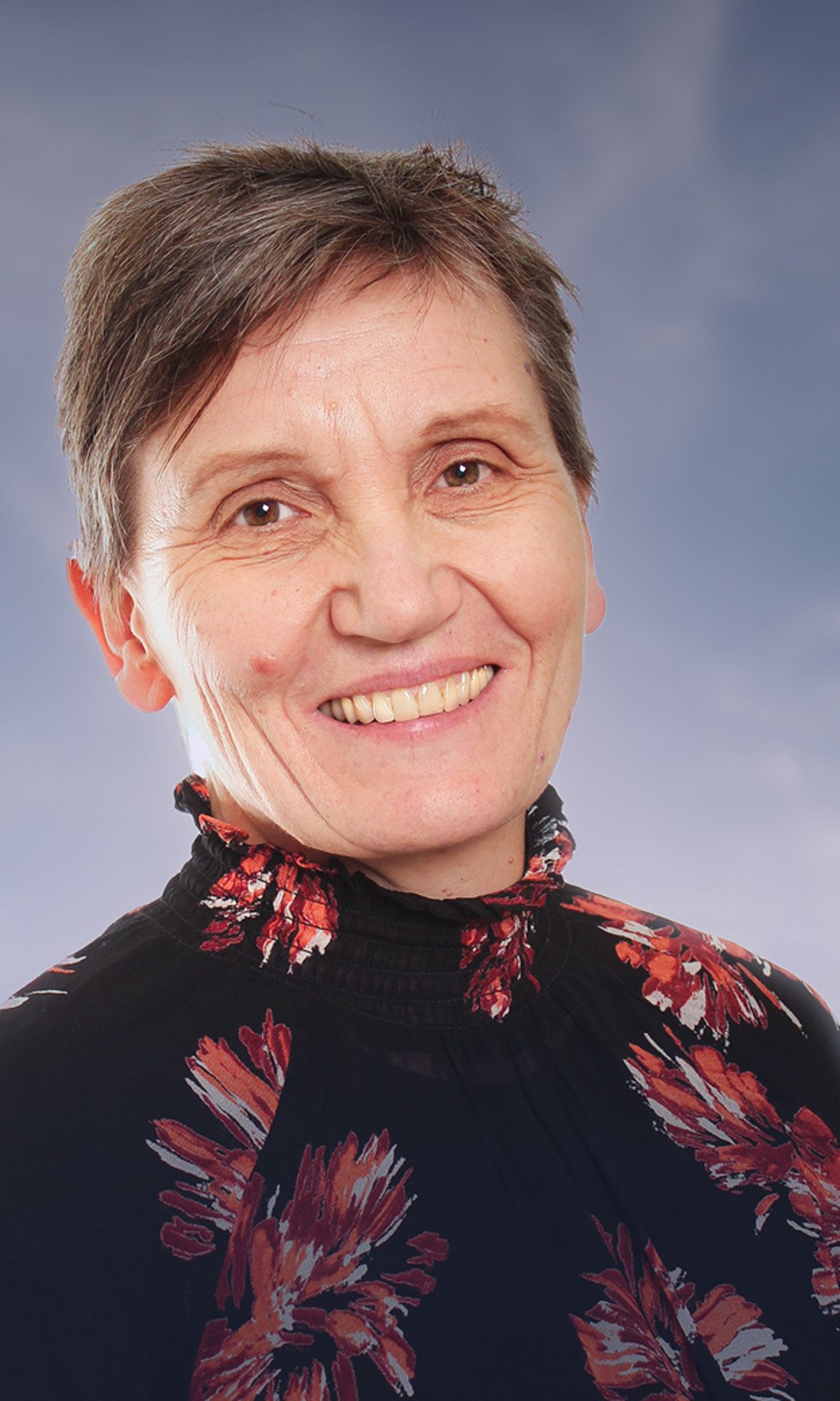 Portrettbilde av Solveig Hofvind i Kreftregisteret, med en lettskyet himmel i bakgrunnen. Foto.